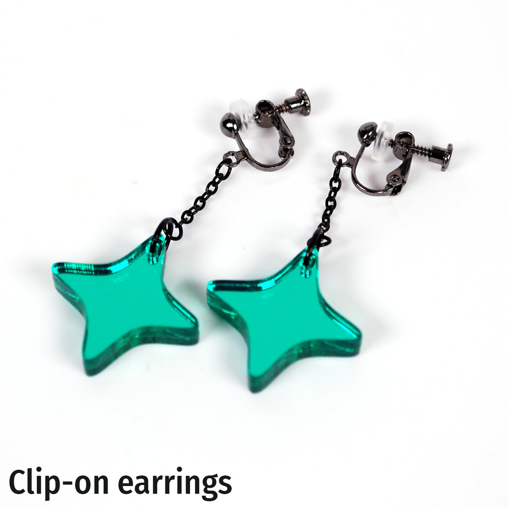 A pair of clip-on star-shaped dangle earrings with translucent teal-green star pendants and dark metal posts, shown on a plain white background with the text 'Clip-on earrings' at the bottom.