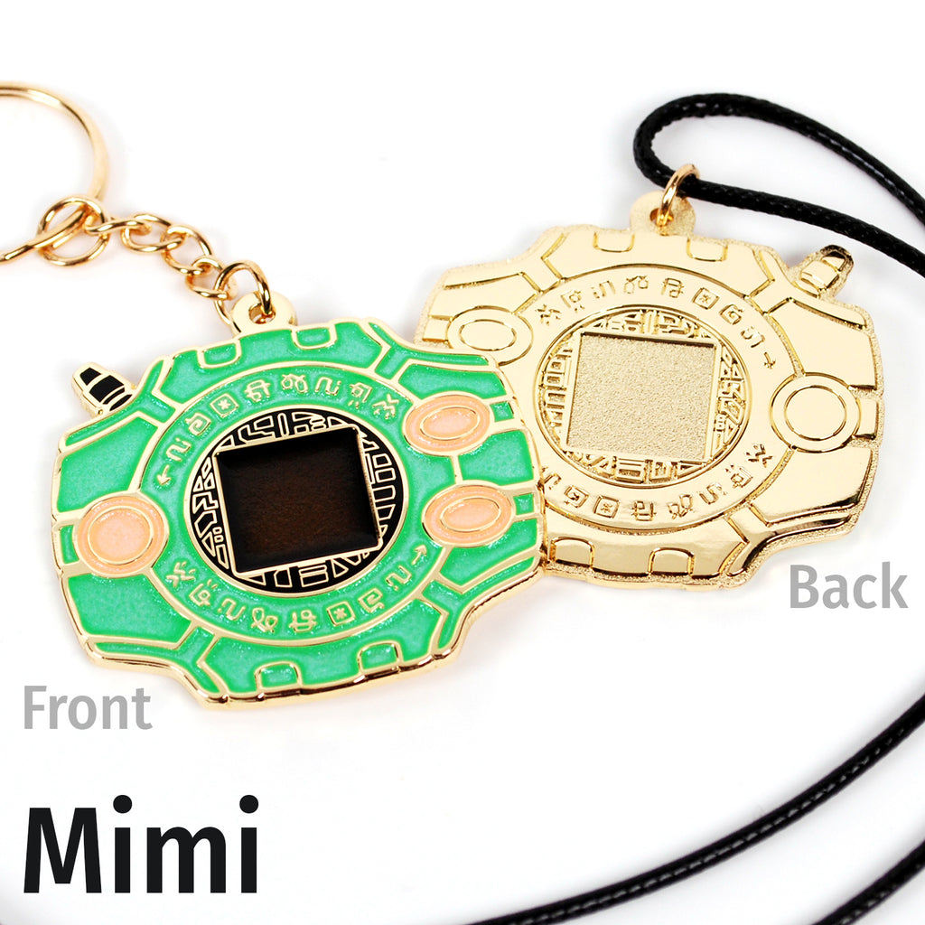 Front and back of Mimi digivice, showing green and light orange colors on gold metal with a keychain or necklace attachment.