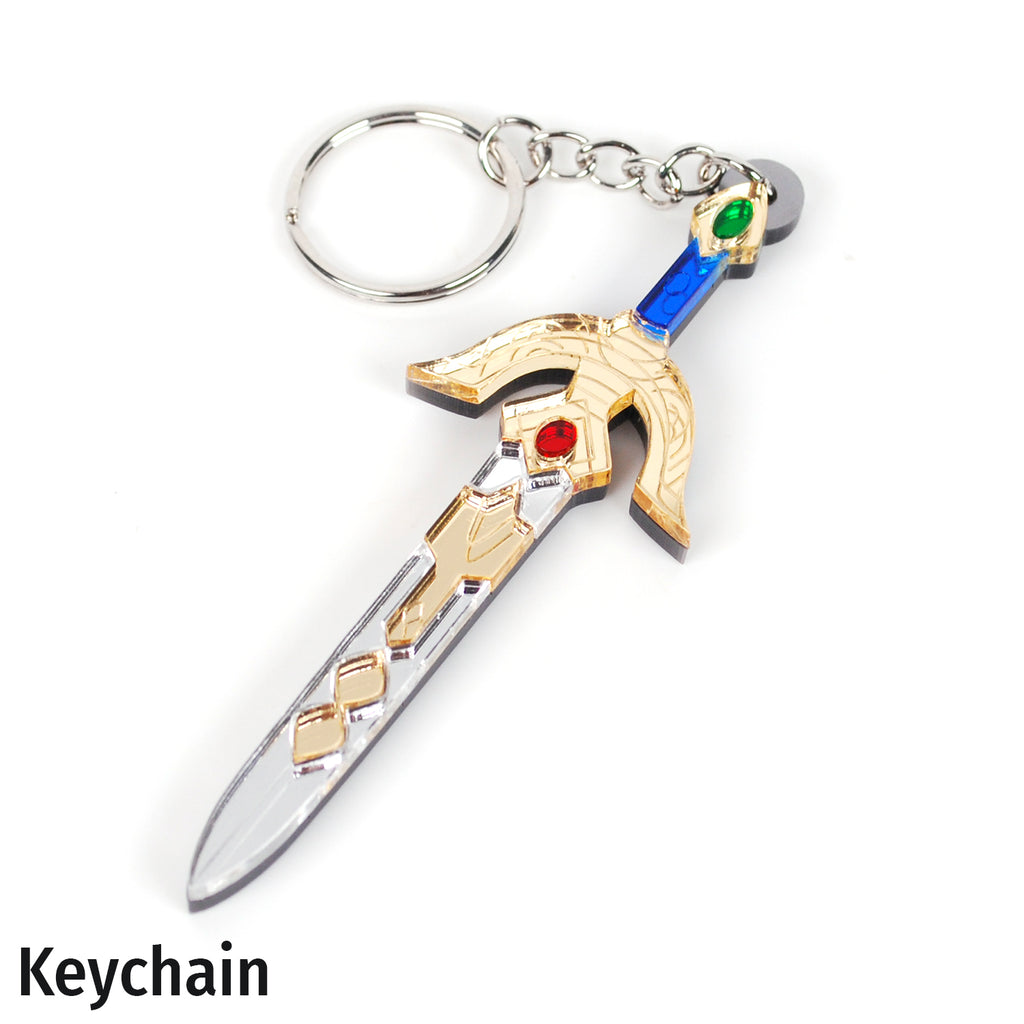 A miniature replica keychain shaped like a fantasy sword with a silver blade, gold hilt, blue grip, and red and green gem accents, attached to a silver split keyring on a white background.