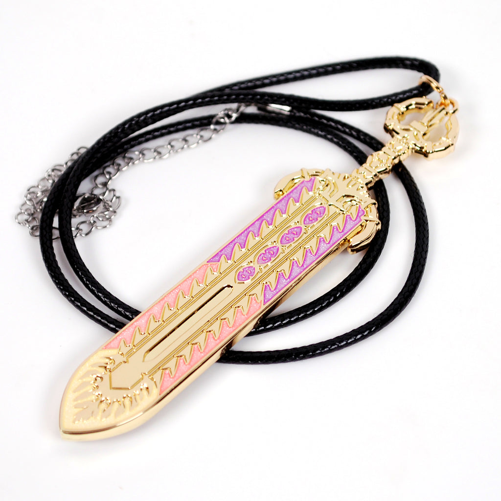 A gold-colored pendant shaped like a decorative sword, shown on a black braided cord necklace. The pendant has engraved patterns with pink, orange, and yellow pearlescent enamels. It is photographed on a white background.