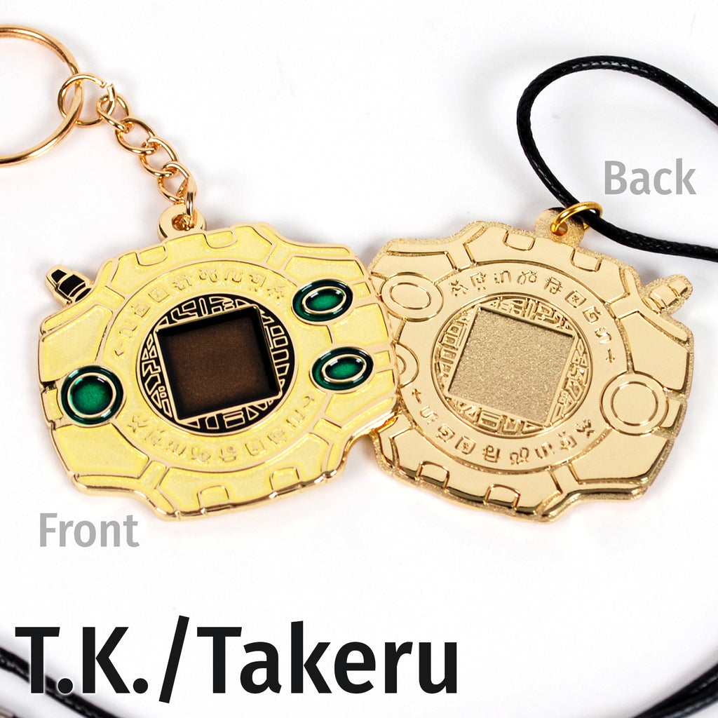 Front and back of TK digivice, showing light yellow and green colors on gold metal with a keychain or necklace attachment.