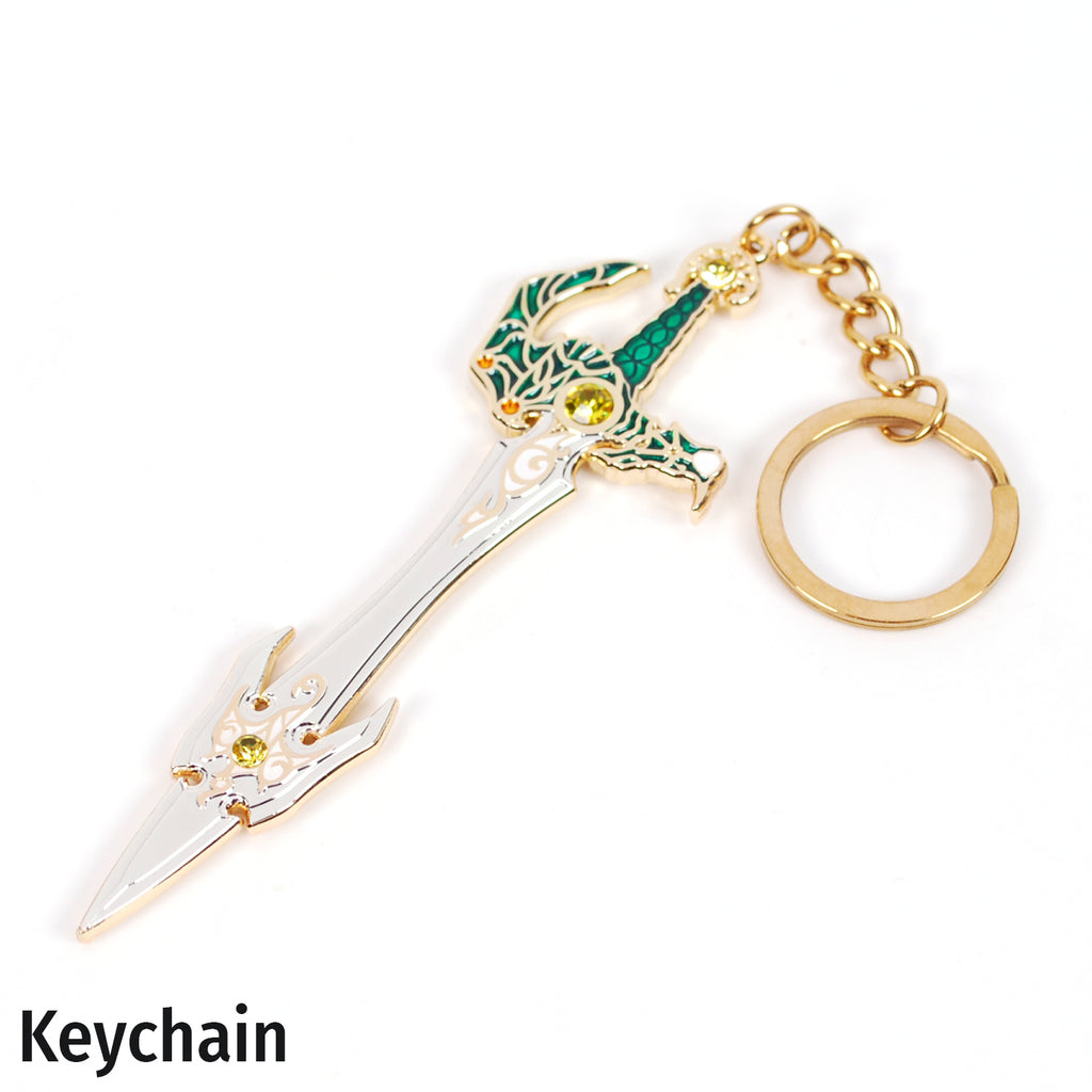 A fantasy keychain shaped like a decorative sword with a gold-colored metal body, green and white enamel detailing on the hilt, small yellow gem accents, and a gold split key ring, shown on a plain white background with the word 'Keychain' printed in the lower left corner.